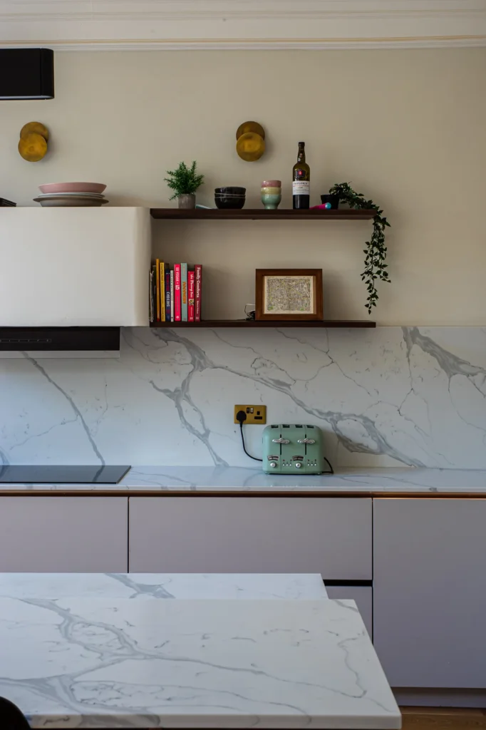 Cashmere matt handleless kitchen with fluted walnut island and marble worktops