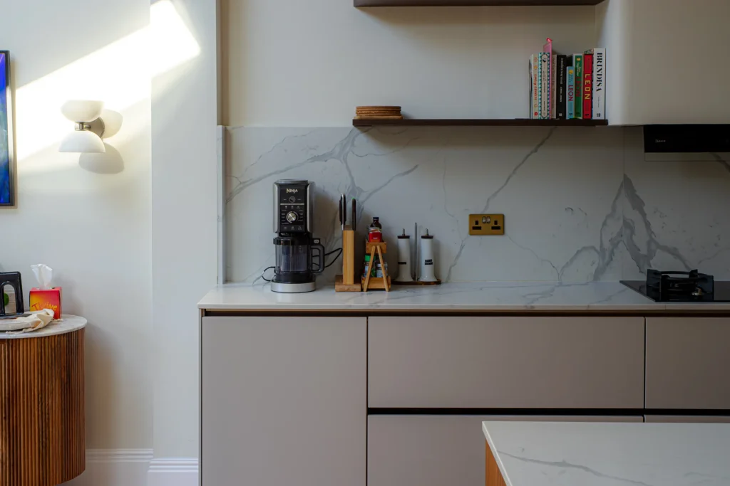 Cashmere matt handleless kitchen with full-height cabinetry and integrated Neff ovens