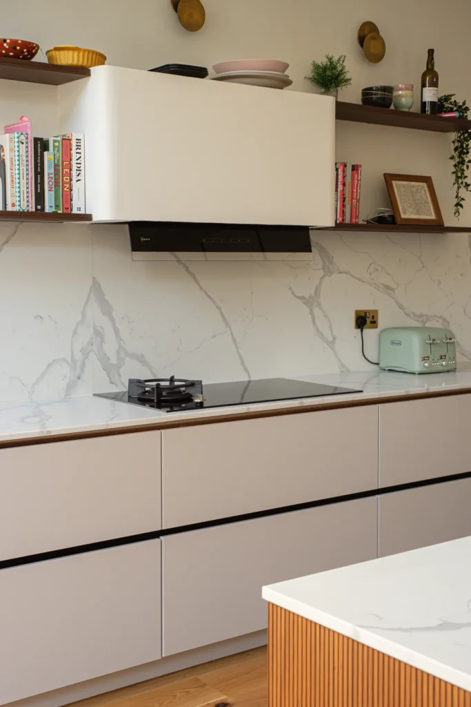 Signature cashmere matt kitchen with marble splashback and open walnut shelving