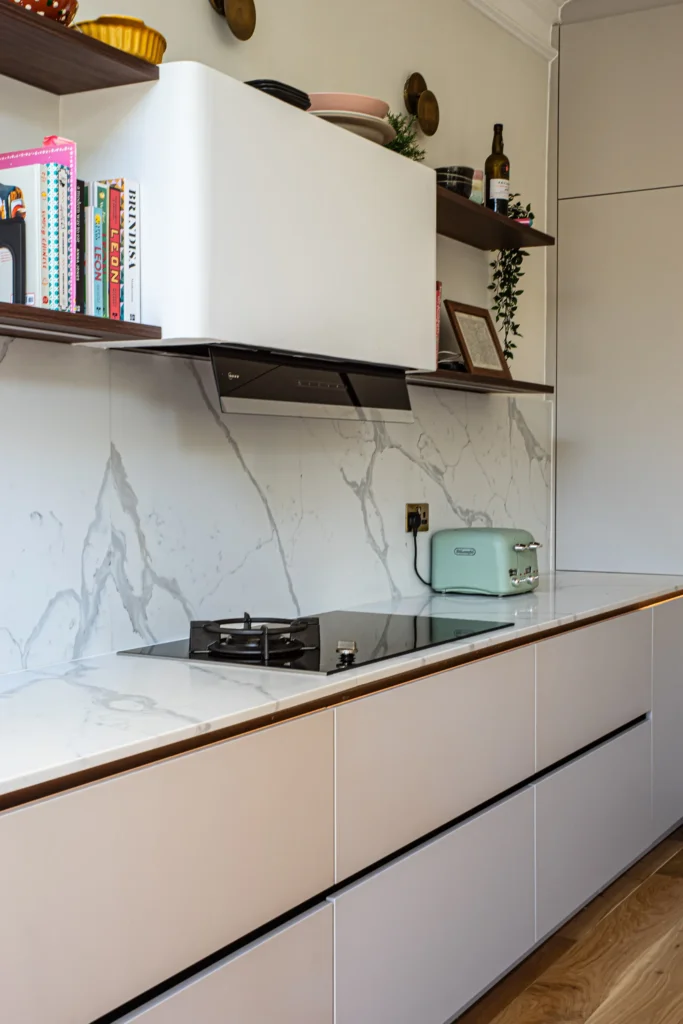 Cashmere matt handleless kitchen with fluted walnut island and marble worktops