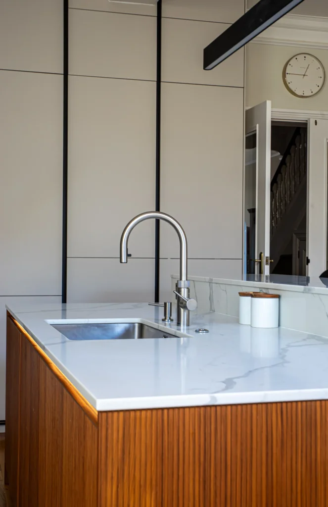 Cashmere matt handleless kitchen with full-height cabinetry and integrated Neff ovens
