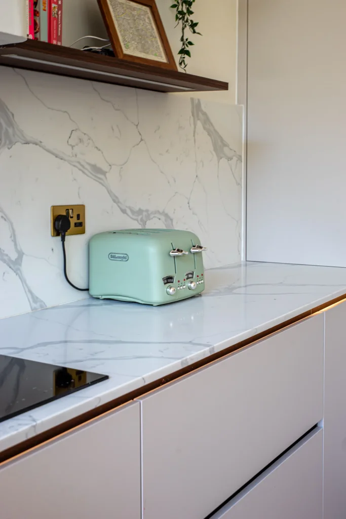 Cashmere matt handleless kitchen with fluted walnut island and marble worktops