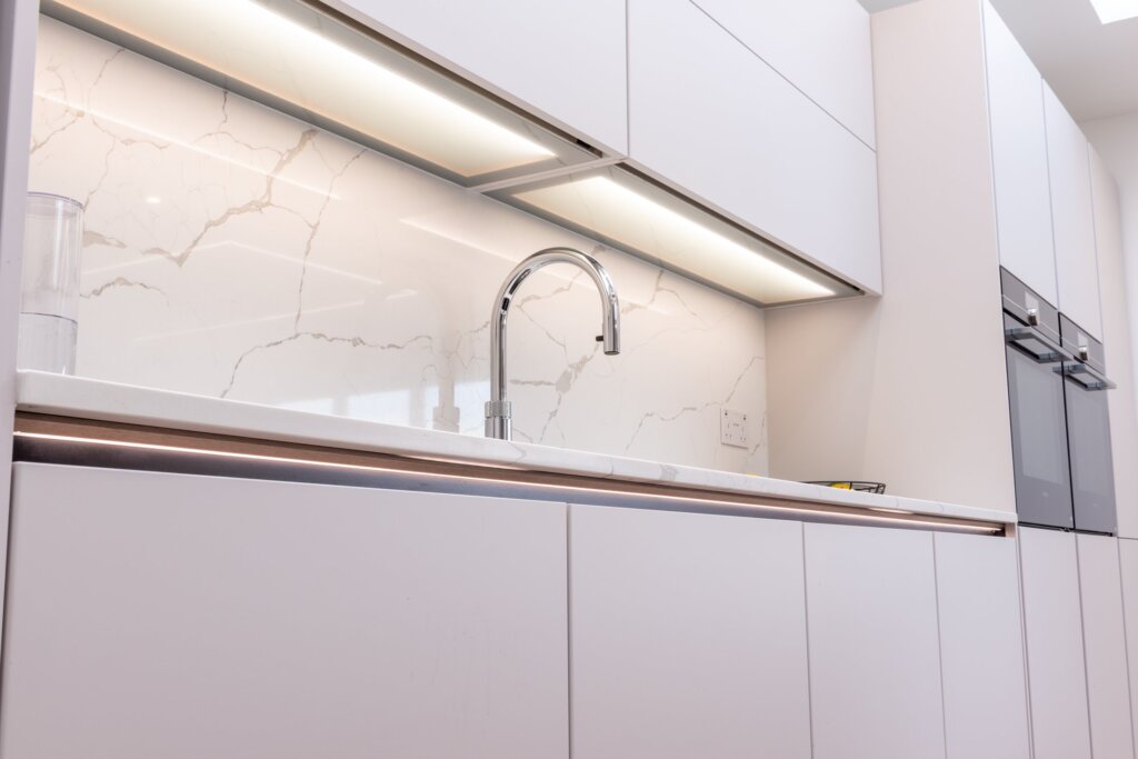 White matt handleless kitchen with graphite black island and marble worktops