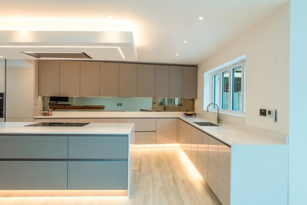 Cappuccino gloss handleless kitchen with dove grey island and white quartz worktops