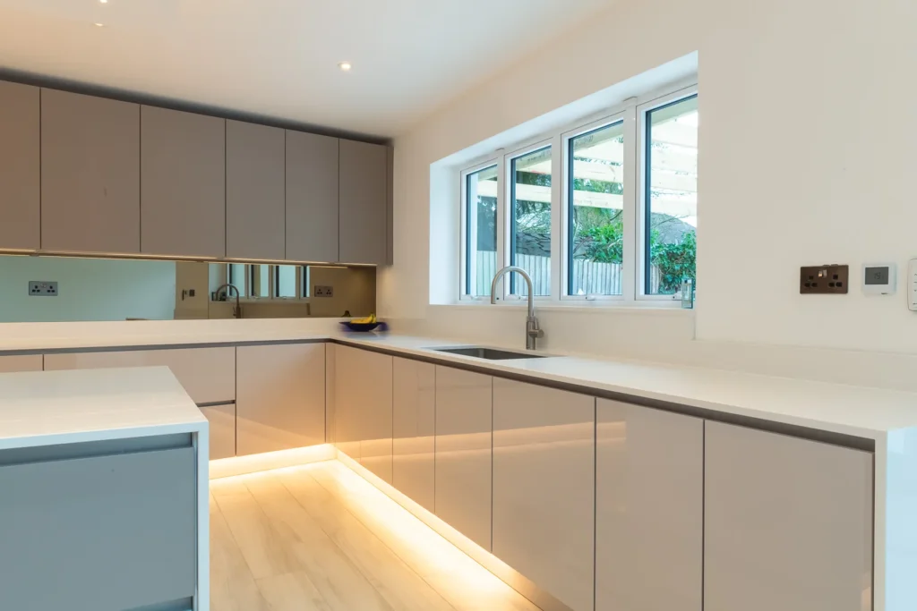 Cappuccino gloss handleless kitchen with mirrored splashback and integrated Samsung ovens