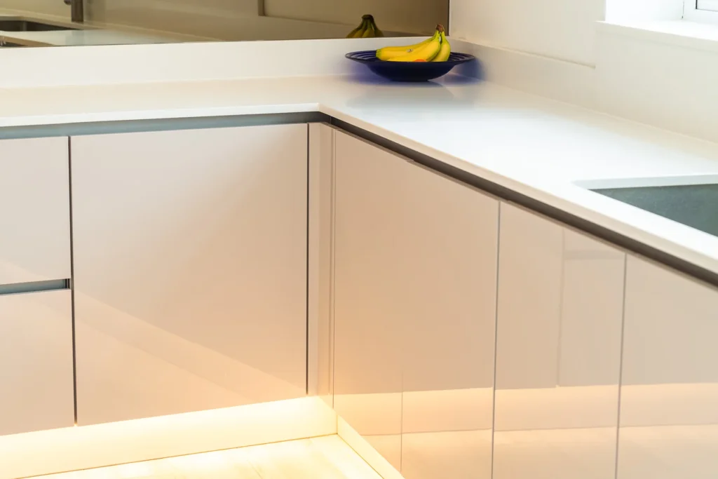 Cappuccino gloss handleless kitchen with dove grey island and white quartz worktops