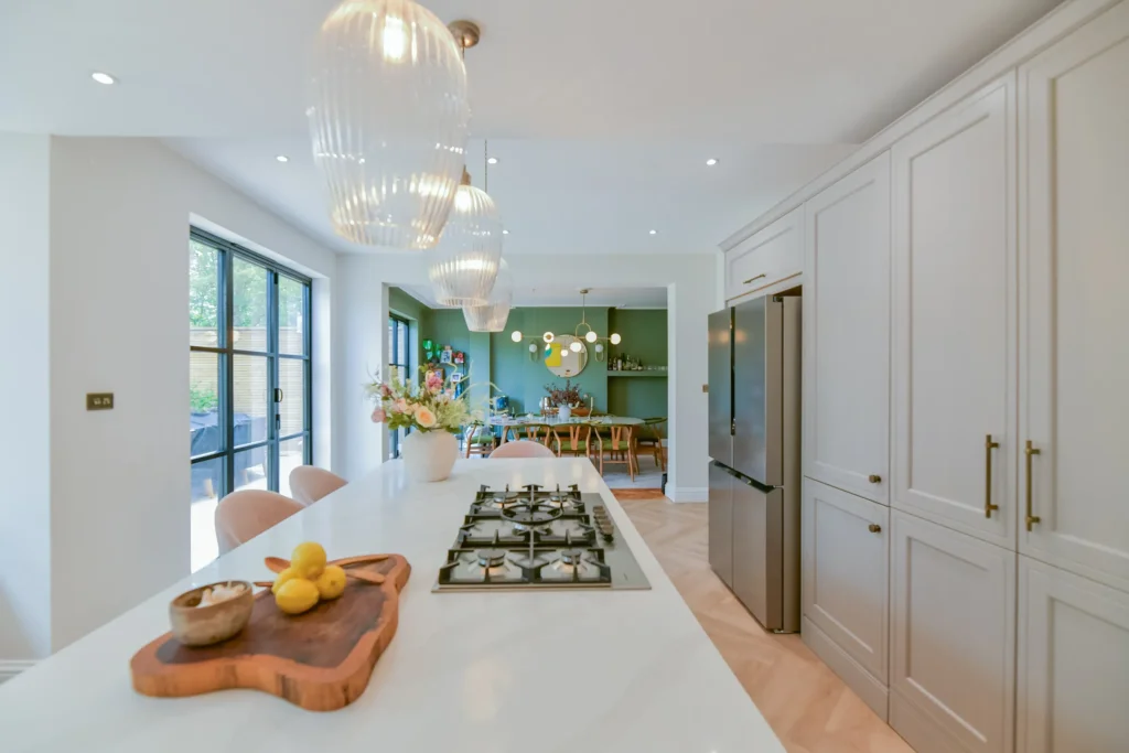Oak veneer handleless kitchen with aged brass tap and quartzite splashback