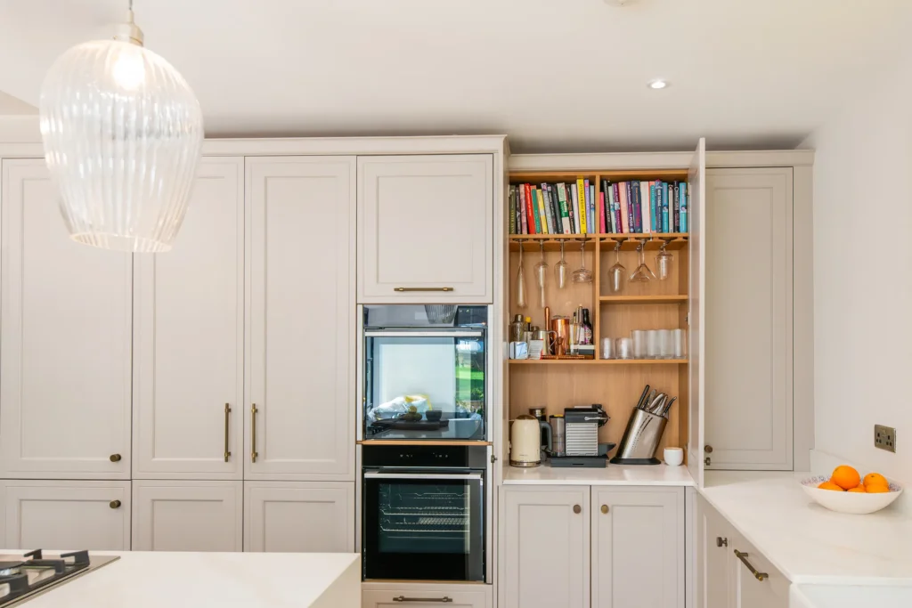 Oak veneer handleless kitchen with backlit quartzite island and marble worktops