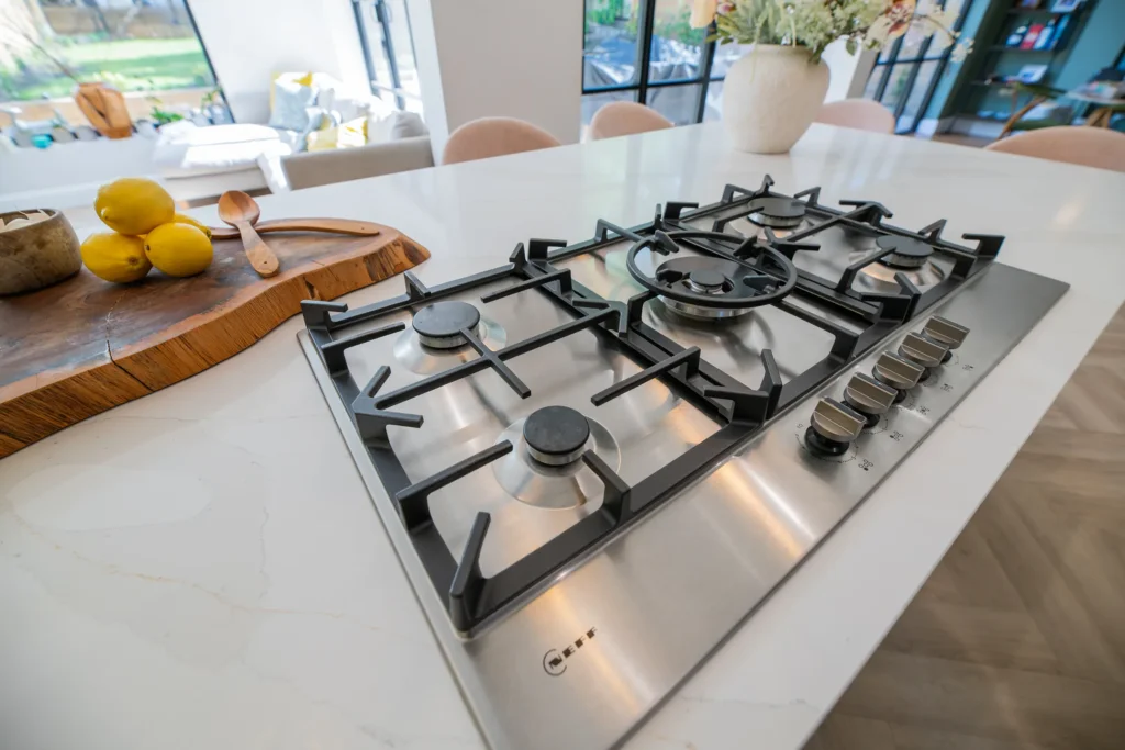 Oak veneer handleless kitchen with backlit quartzite island and marble worktops