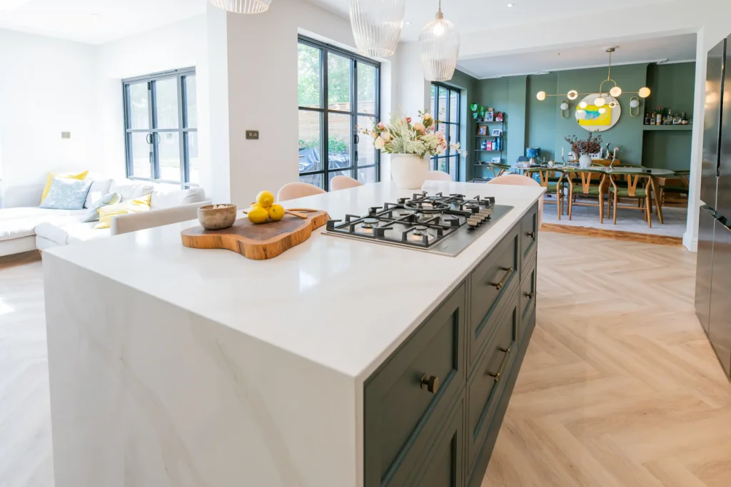 Oak veneer handleless kitchen with backlit quartzite island and marble worktops