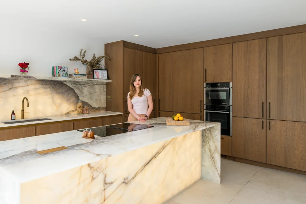 Oak veneer handleless kitchen with aged brass tap and quartzite splashback