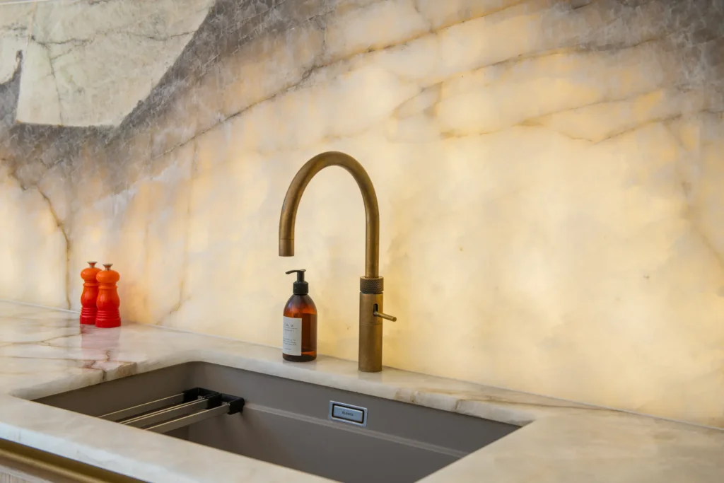 Oak veneer handleless kitchen with backlit quartzite island and marble worktops
