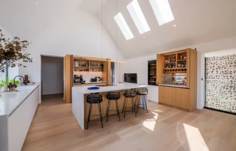 White handleless kitchen with oak cabinetry and marble-topped island