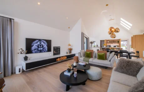 White handleless kitchen with oak island flowing into open-plan dining area