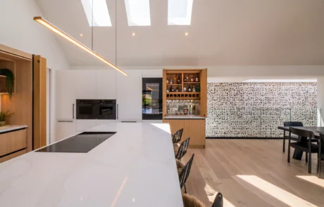 White handleless kitchen with black galley pantry and marble worktops