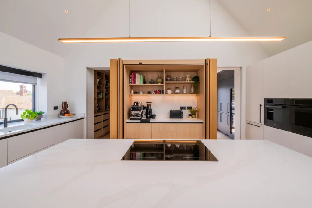 Signature white handleless kitchen with oak bi-fold pantry and coffee station
