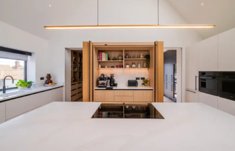 Signature white handleless kitchen with oak bi-fold pantry and coffee station