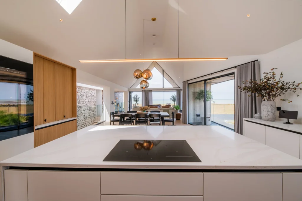 White handleless kitchen with black galley pantry and marble worktops