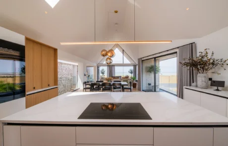 White handleless kitchen with black galley pantry and marble worktops