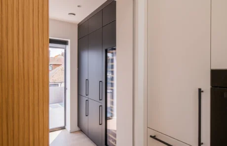 Signature white handleless kitchen with oak bi-fold pantry and coffee station