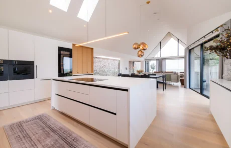 White handleless kitchen with black galley pantry and marble worktops