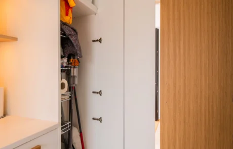 White handleless kitchen with oak drinks cabinet and integrated wine store