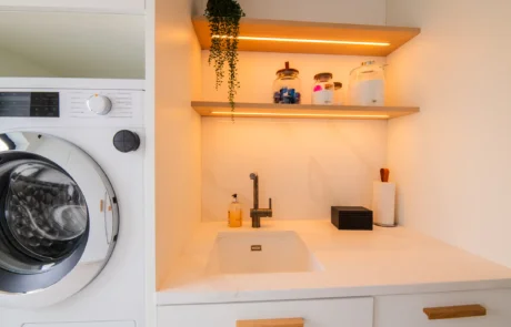 White handleless kitchen with oak island flowing into open-plan dining area