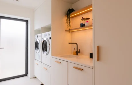 White handleless kitchen with black galley pantry and marble worktops