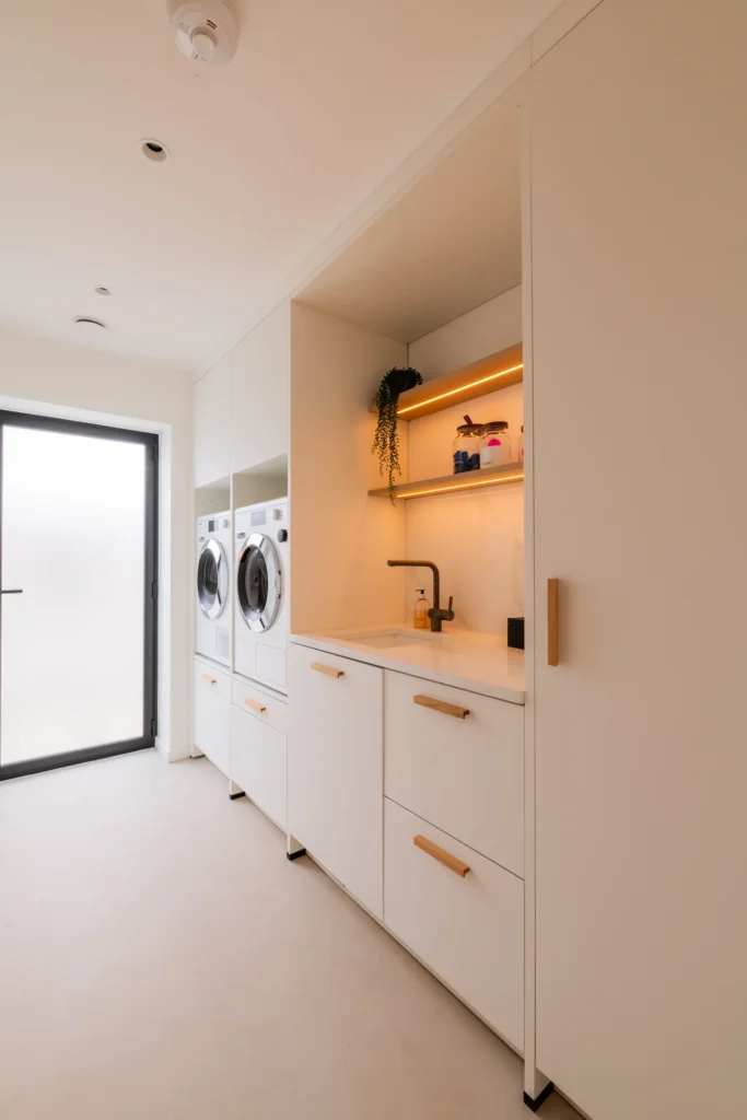 White handleless kitchen with black galley pantry and marble worktops
