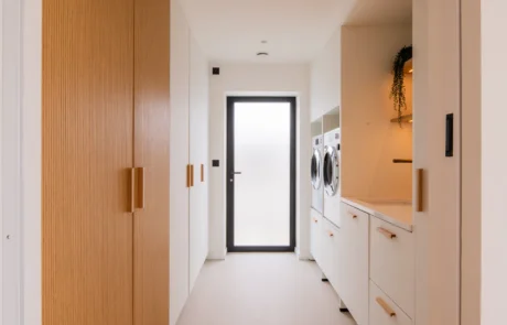 White handleless kitchen with oak cabinetry and marble-topped island