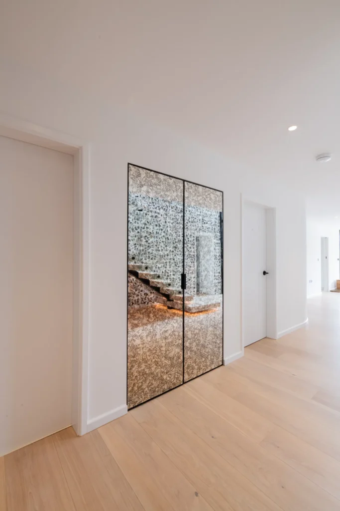 White handleless kitchen with oak island flowing into open-plan dining area