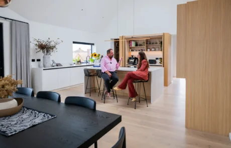 White handleless kitchen with vaulted ceiling, skylights and sea views