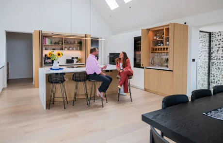White handleless kitchen with oak drinks cabinet and integrated wine store