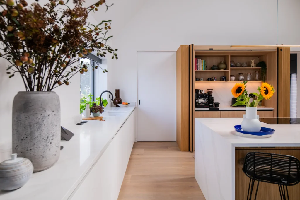 White handleless kitchen with black galley pantry and marble worktops