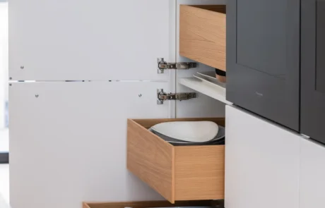 White handleless kitchen with oak cabinetry and marble-topped island