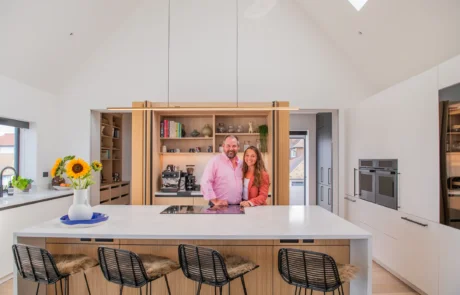 White handleless kitchen with vaulted ceiling, skylights and sea views
